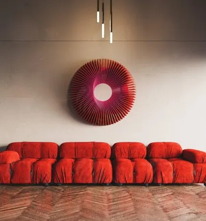 A direct shot of the red 'Radiant Circles' art, emphasizing its vibrant color and the mesmerizing pattern created by the radiating wooden slats.