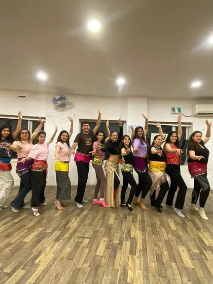 The adult belly dance group, feeling empowered and energized after learning new moves.