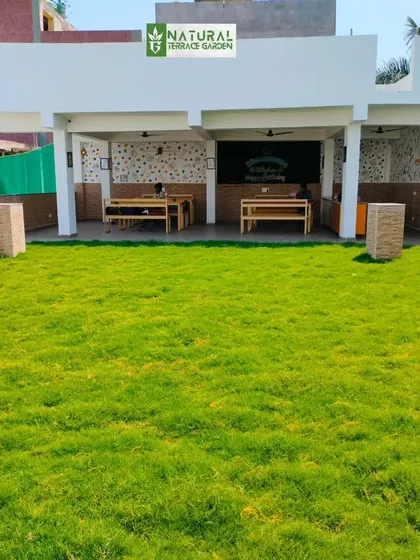 A completed rooftop project in Dwarka Mor featuring an expansive natural lawn, perfect for events or as a play area.