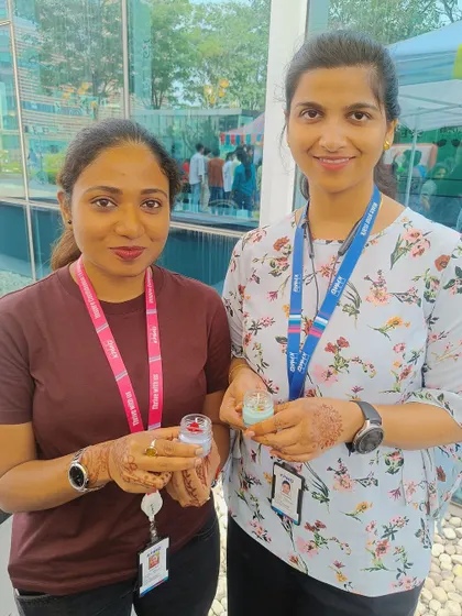 Two employees show off their small, custom-made candles, created at our live booth during a corporate campus event.