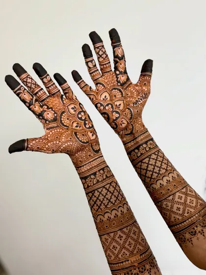 The back of the hands, featuring a lovely floral and vine pattern that extends up the arms.