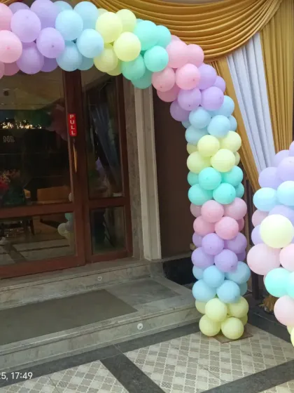 A pastel rainbow balloon arch marks the entrance to this princess-themed birthday party.