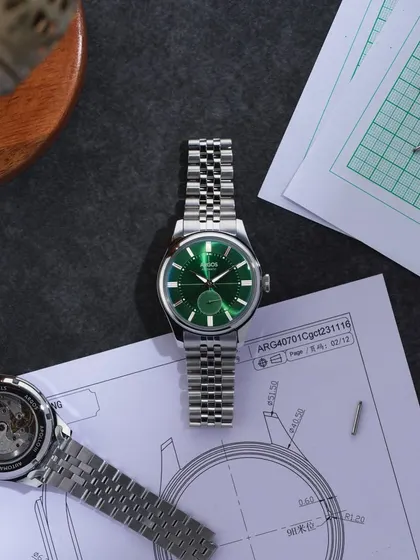 A "work in progress" flat lay. This shot places the Argos watch among technical drawings and tools, telling the story of its design and creation. It connects the final product to the craft and precision behind it.