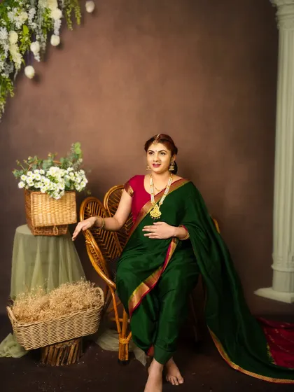 A regal seated portrait. The mom to be looks serene and majestic in her green saree, a perfect celebration of motherhood and tradition.