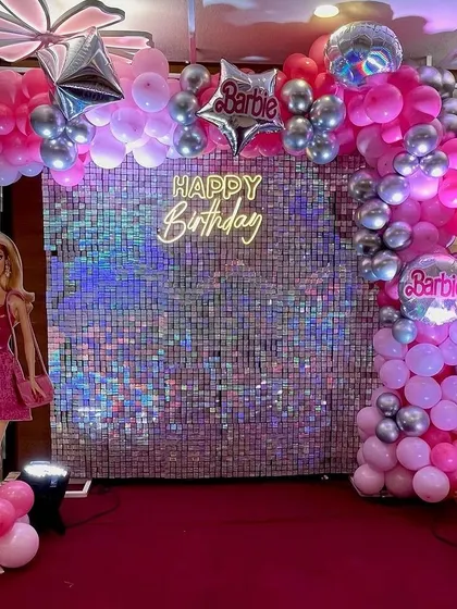 A closer view of the Barbie birthday decoration. The pink and silver color scheme with the shimmer wall creates a chic and fun atmosphere for the party.