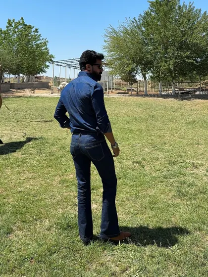 The back view of our denim ensemble, showcasing the perfect fit of the bootcut jeans and the shirt's tailored silhouette.