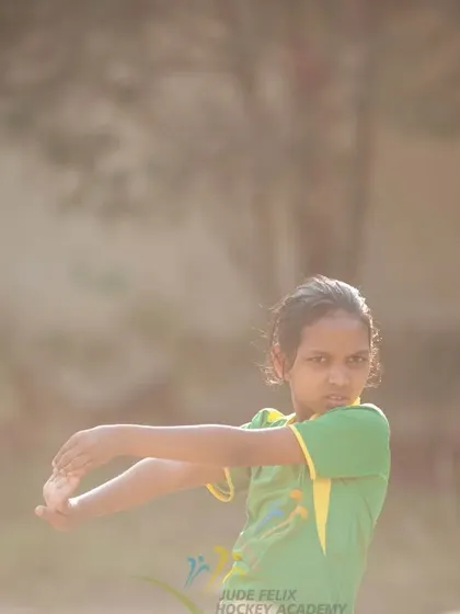 A young girl stretches during warm-ups at the 2022 camp, preparing her body for the session ahead.