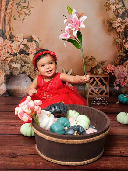 From the same floral session, this shot captures a moment of curiosity as she holds a lily. Sitter sessions are full of movement and discovery, and I make sure to capture these candid, interactive moments as well as the posed smiles.