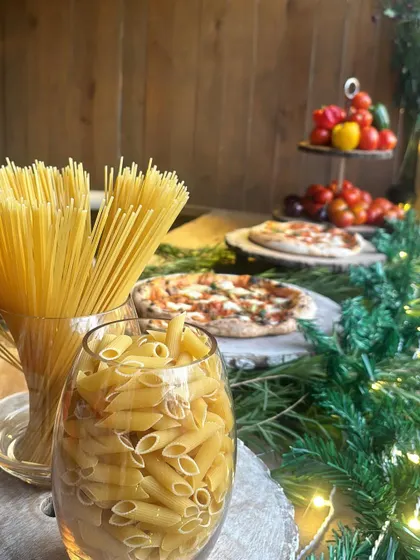 It's all about fresh ingredients. This display shows the raw penne and spaghetti, ready for our live pasta station, with fresh tomatoes and pizzas in the background.