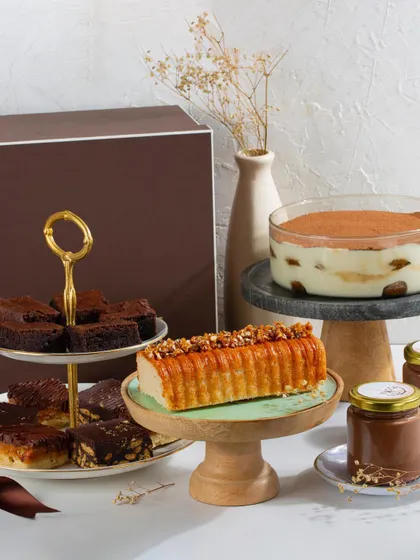 A festive spread showcasing our Christmas favourites. This collection includes our Classic Tiramisu, Dark Chocolate Mousse, a Vanilla Salted Caramel Loaf, and an assortment of our popular dessert bars.