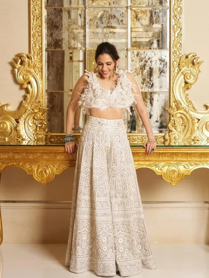 For Manish Malhotra's Diwali party, we chose this gorgeous white chikankari lehenga from his collection. The feather-detailed top adds a touch of modern glamour to the traditional skirt.