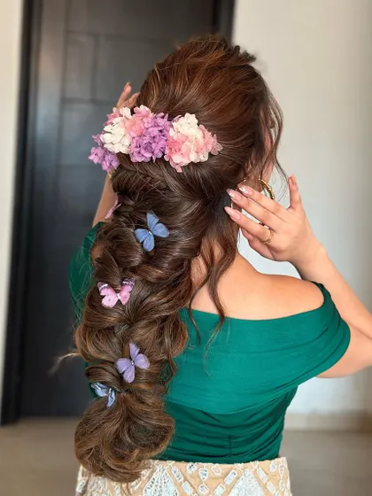 A whimsical textured mehendi braid adorned with flowers and butterflies. This look is pure magic, and the volume from the extensions is what makes it so breathtaking.