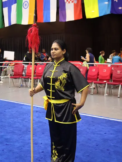 Standing ready with a staff (gun) at an international competition. The staff is one of the first weapons a student learns, known as 'the father of all weapons' in Kung Fu.