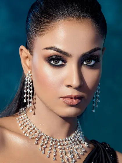 A powerful, direct-to-camera beauty shot. The intense gaze is amplified by the dark eyeliner and the cascading diamond necklace and earrings.