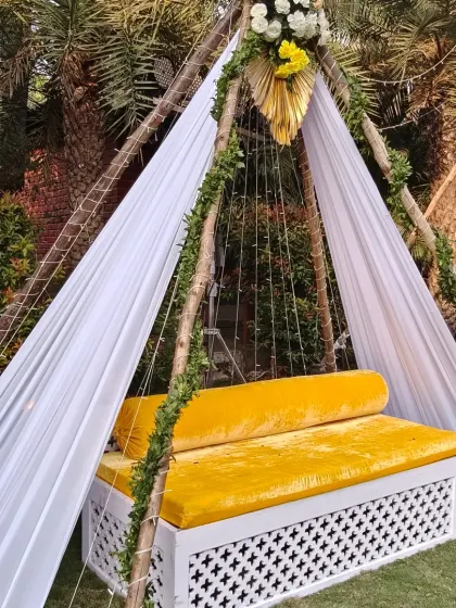 A cozy and chic seating spot for a Haldi or Mehendi event. This teepee-style cabana with bright yellow seating is perfect for the bride or for guests to take pictures.