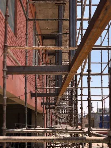 The intersecting geometries of a steel exoskeleton during construction. This raw, modular structure will eventually form the defining feature of the building's facade.