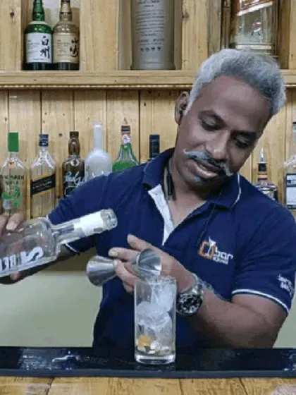 Pouring a measure of vodka for a classic cocktail. My setup includes all the necessary professional bartending tools and a wide range of spirits to craft any drink your guests desire.