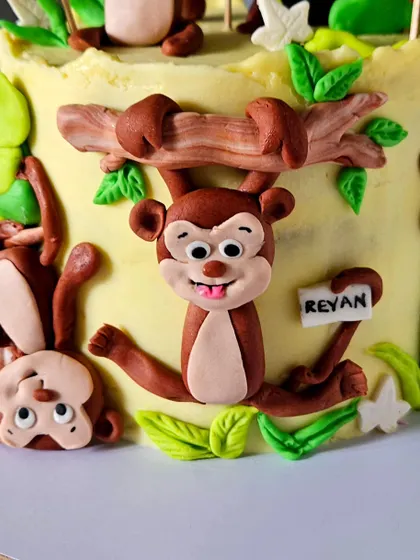 This close-up shows the monkeys hanging from vines and playing around the cake, adding a sense of movement and fun to the design.