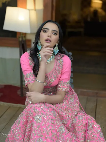 A beautiful portrait in a vibrant pink lehenga. The makeup is kept soft and neutral to let the outfit shine.