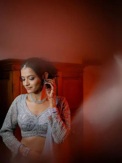 A creative portrait of the bride, Anusha, with a red light leak effect, adding an artistic and modern touch to her reception photos.