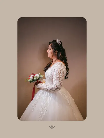 A simple and elegant portrait of the bride in her beautiful white gown, holding a bouquet of red and white roses.
