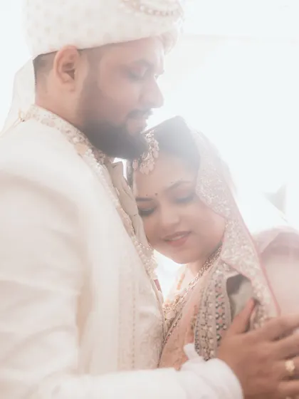 A soft, light-filled embrace between the bride and groom. Her head rests on his chest, a picture of comfort, trust, and quiet love. The dreamy backlighting makes this moment feel even more magical.