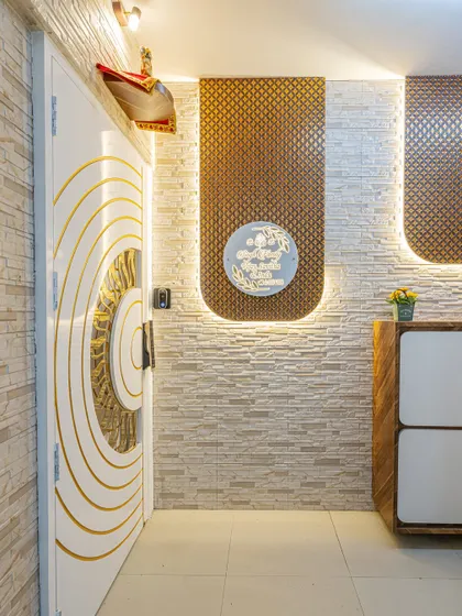 The foyer area is designed to be both welcoming and functional. The backlit panels and stone-clad wall add texture and warmth, while the custom cabinet provides storage.
