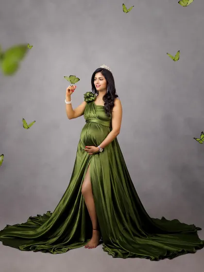 A touch of whimsy with digital butterflies surrounding the mother-to-be in an olive green satin gown. This adds a playful and magical element to the portrait.