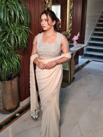 This full-length shot captures the grace of the modern saree and the refined makeup look, perfect for an engagement or cocktail event.