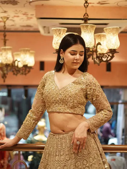 Turn heads in this gold embellished lehenga, paired with a dazzling sequin work blouse. A flawless blend of luxury and shine for any event.