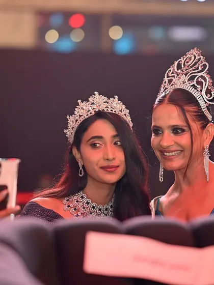 A selfie moment between two pageant winners. This fun, modern shot shows the camaraderie and joy behind the competitive event.