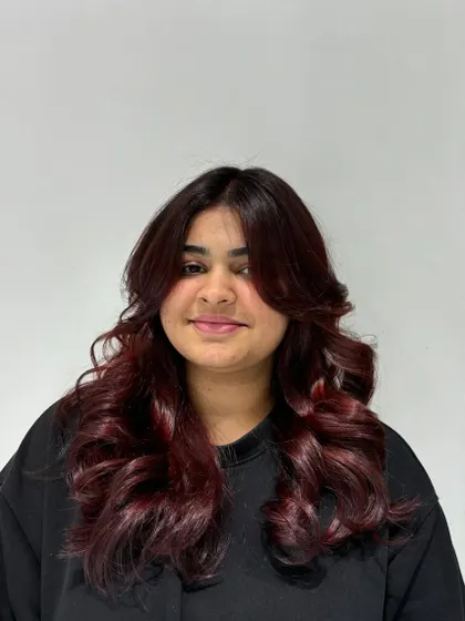 The auburn color looks rich and vibrant, adding warmth and personality to her overall style.