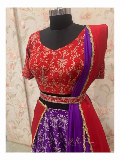 The front view of the red and purple half saree set on a mannequin.