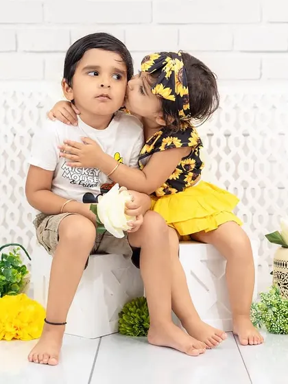 An incredibly sweet and unposed moment of sibling love. A little sister gives her brother an affectionate kiss on the cheek, a perfect example of the real, heartfelt interactions I aim to capture.