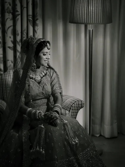 A timeless black and white bridal portrait of Mayuri, capturing a quiet moment of contemplation.