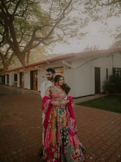 A wide shot of the couple, showcasing their beautiful, colorful outfits against the backdrop of the venue.