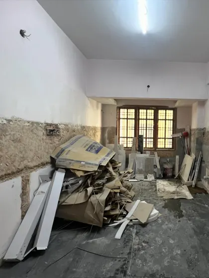 The kitchen space before renovation, filled with debris and ready for a complete overhaul.