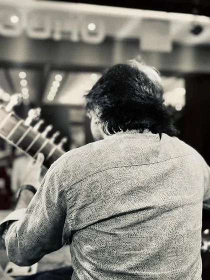 A black and white shot from behind, capturing a moment on stage. For me, music is about igniting souls and sharing the magic of live performance.