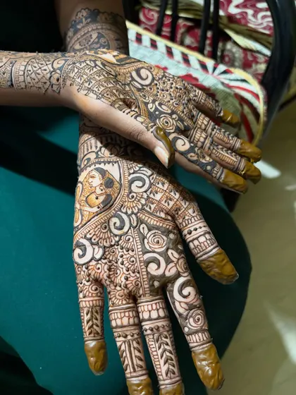 A side view of the bridal mehendi, highlighting the detailed swirls and floral patterns that fill the design. Every part of the hand is covered in beautiful, fine lines.