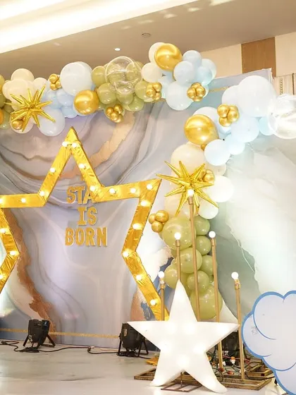 A 'Star is Born' themed naming ceremony. The lit-up star, moon, and cloud props against a marble backdrop created a celestial wonderland.