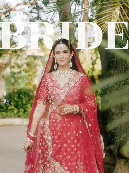 A classic bridal portrait with the bride looking directly at the camera, framed by lush greenery. The "BRIDE" text overlay makes a bold statement.