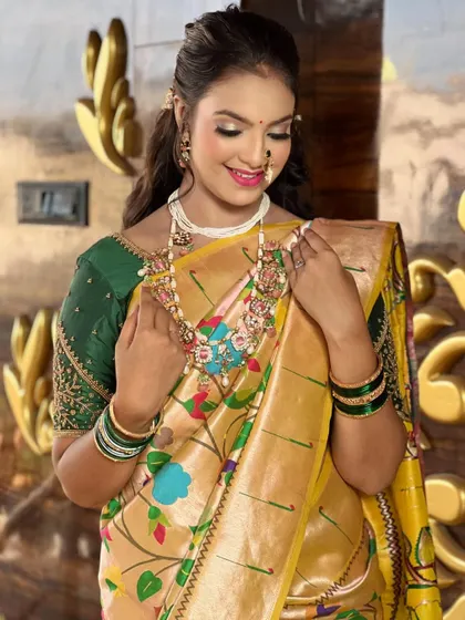 A graceful pose showing the intricate floral patterns of the `Paithani` saree and the heavy bridal jewelry.
