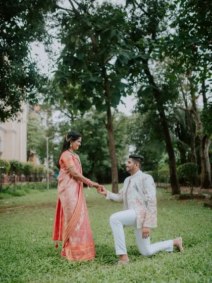 A classic proposal pose in a beautiful green park, part of an engagement photoshoot.