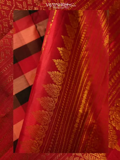 A close-up of the checked Kanjivaram's border, showing the intricate leaf motifs woven in gold zari.