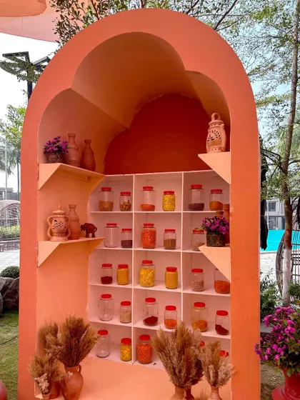 An arched nook filled with jars of colorful spices, creating a beautiful and aromatic display that enhances the multi-sensory experience of the event.