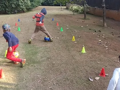 Two players practice their dribbling skills, weaving through a course of colorful cones. This drill is essential for developing close ball control and agility.