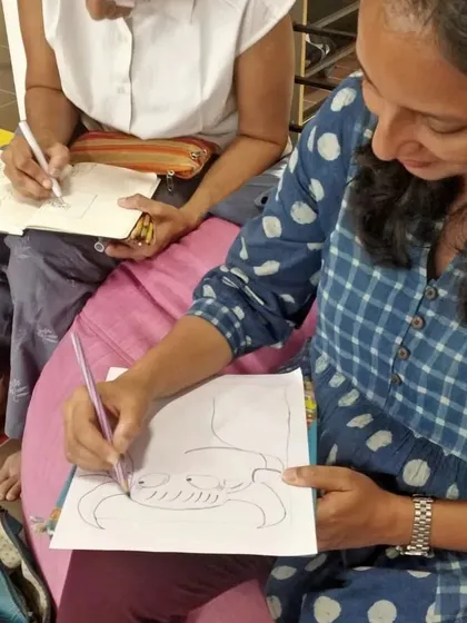 Even the parents couldn't resist joining in! Here, a parent is sketching along with the kids during our illustrator workshop, making it a fun family activity.
