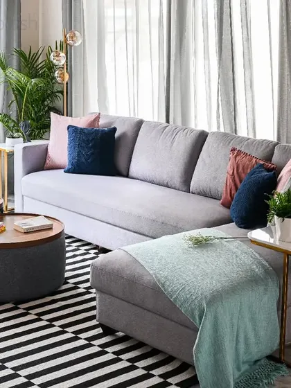 This comfortable L-shaped sofa is styled with a mix of cushions and a cozy throw. The black and white geometric rug adds a bold graphic element to the living room.