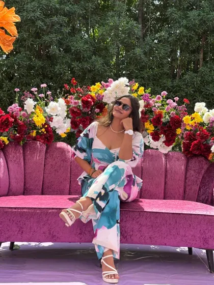 Taking a moment to relax on the plush pink sofa at the carnival-themed wedding event.