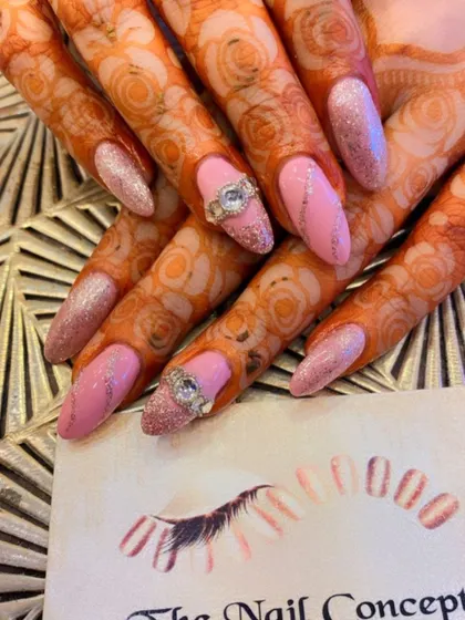 A perfect bridal look with henna-stained hands. The nails feature a soft pink glitter base, silver glitter accents, and a unique 3D silver ring embellishment on the ring fingers.
